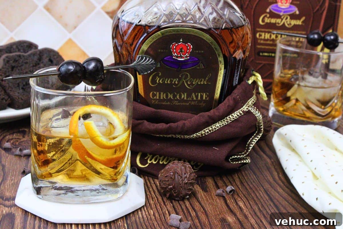 12 Irresistible Chocolate Crown Royal Cocktails to Try Tonight 3 chocolate old fashioned next to chocolate crown royal bottle on a wooden table