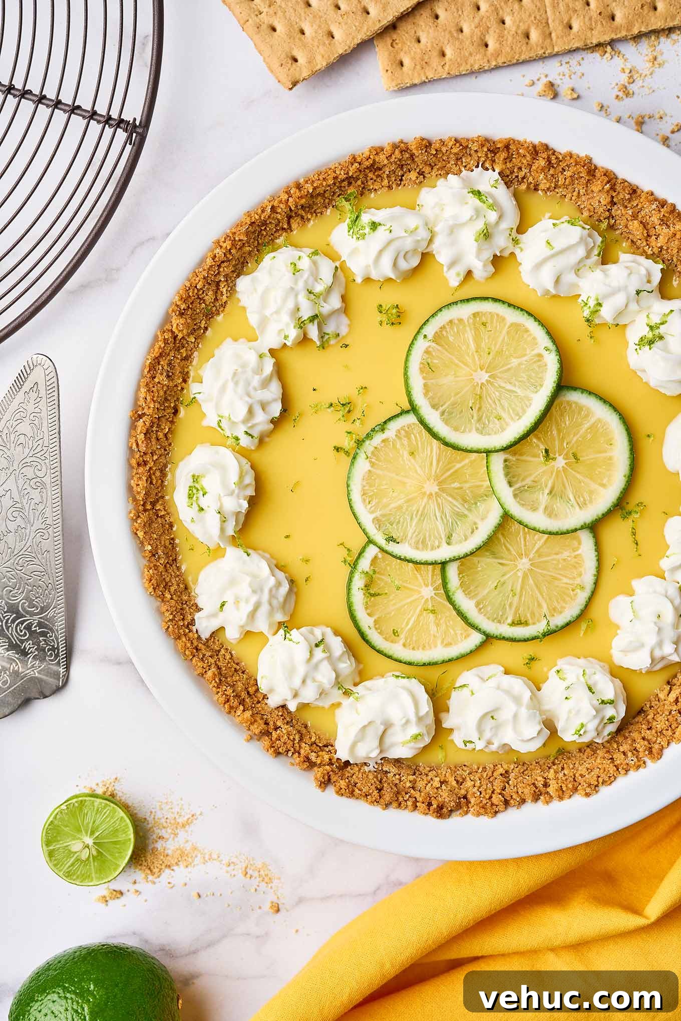 Authentic Florida Key Lime Pie Recipe You’ll Love 2 Florida Key lime pie with graham cracker crust, topped with whipped cream and lime slices in a white pie plate.