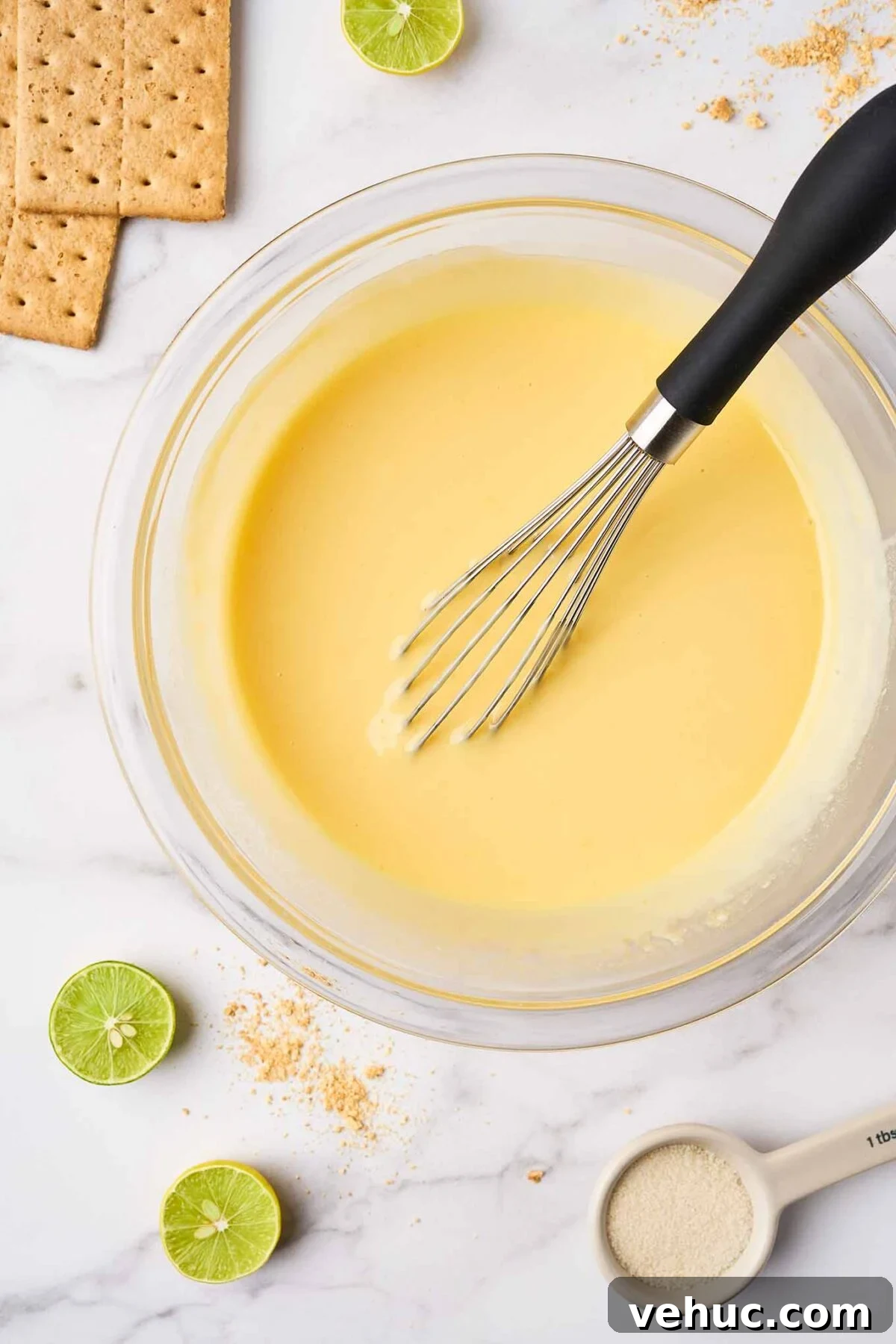 Authentic Florida Key Lime Pie Recipe You’ll Love 5 Key lime pie filling made with egg yolks, lime juice, and sweetened condensed milk being whisked in a bowl.