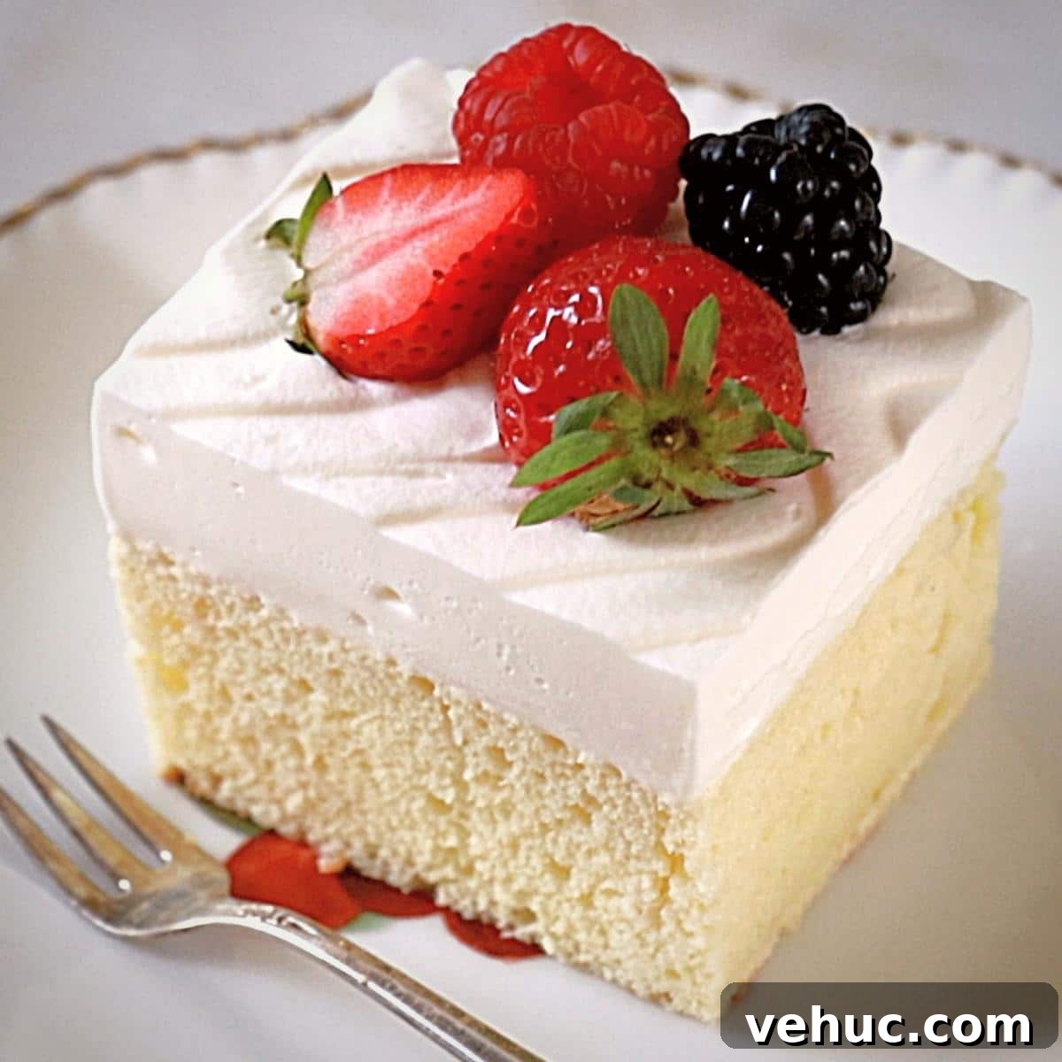 Authentic Tres Leches Cake Recipe: Moist Latin-Style Dessert 2 a tres leches cake on an antique plate with a fork