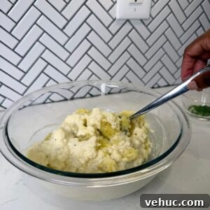 Creamy Garlic Mashed Potatoes Recipe 9 Potatoes in a glass bowl with heavy cream mixture.