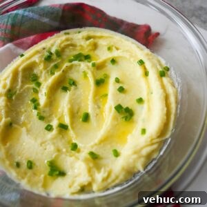 Creamy Garlic Mashed Potatoes Recipe 10 Mashed Yukon gold potatoes topped with melted butter and chopped chives, served in a glass bowl.