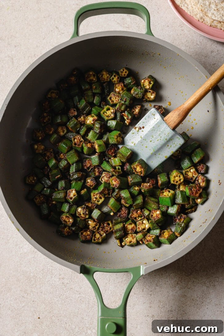 15-Minute Indian-Style Bhindi Fry Recipe for Crispy Okra 12 Close up of Bhindi Fry in a skillet with a spatula.
