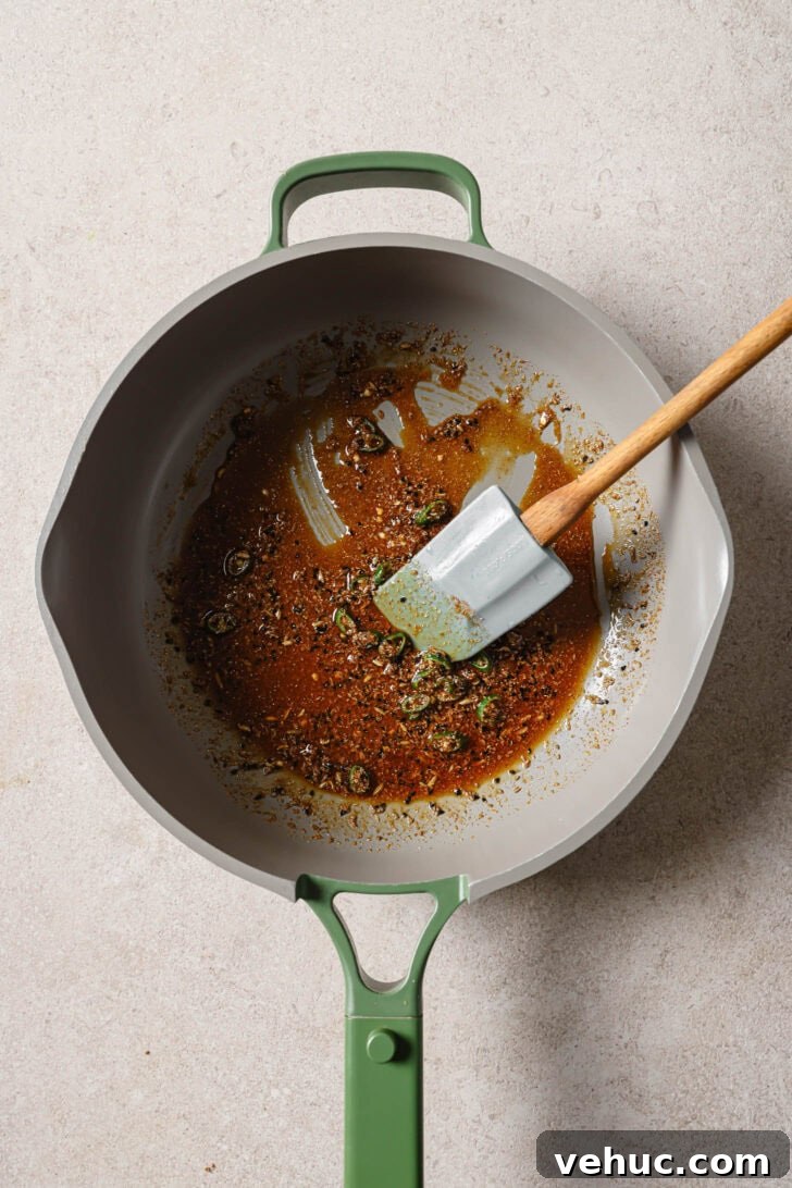 15-Minute Indian-Style Bhindi Fry Recipe for Crispy Okra 8 Green chilies added to sauteéd spices in skillet to make Bhindi Fry.