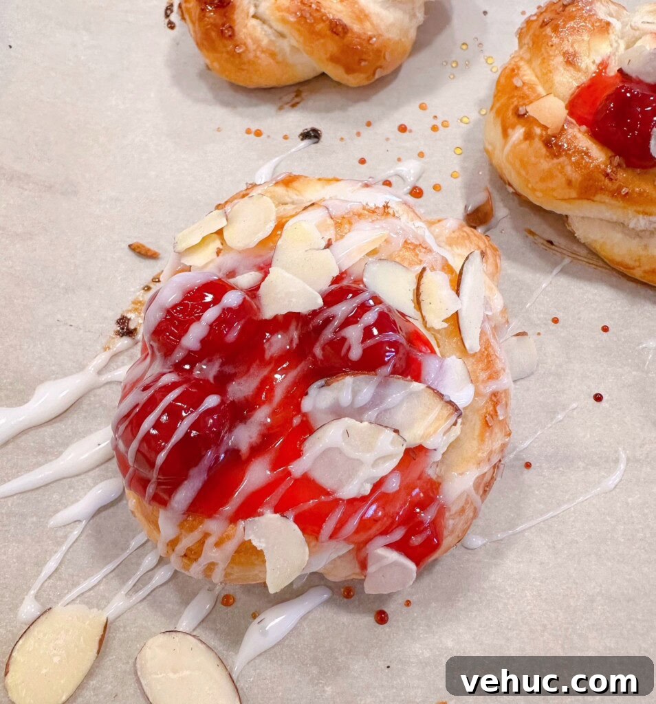 Cherry Cream Cheese Knots: Sweet Stuffed Pastry Bites for Brunch 14 Drizzling icing over cherry danishes and adding sliced almonds.