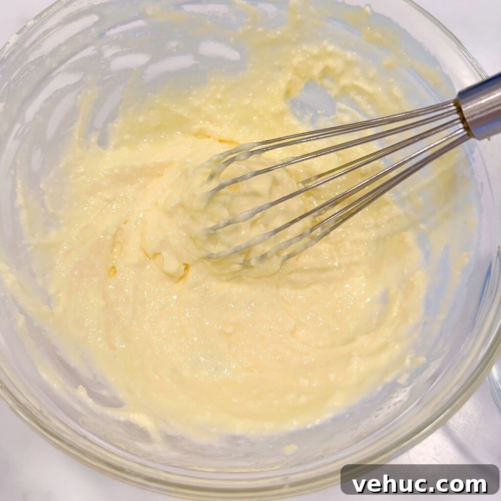 Cherry Cream Cheese Knots: Sweet Stuffed Pastry Bites for Brunch 7 Cream cheese filling in a small bowl with a wisk.