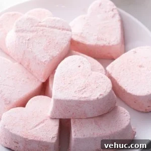 Homemade Strawberry Marshmallows: Soft, Fluffy Recipe 13 Heart-shaped strawberry marshmallows on a white plate.