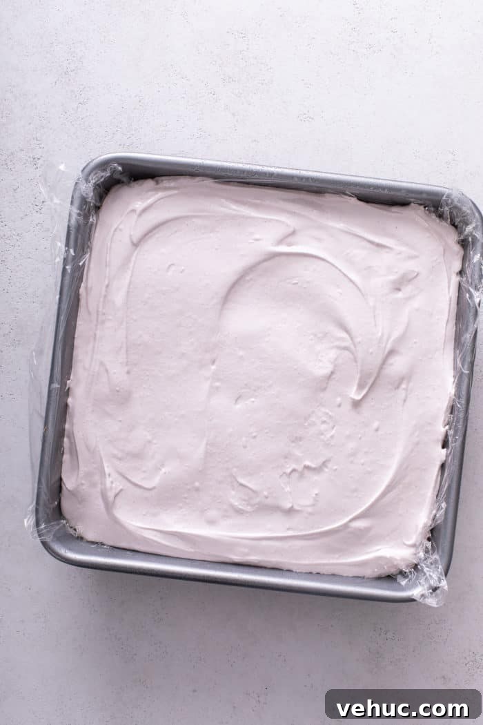 Homemade Strawberry Marshmallows: Soft, Fluffy Recipe 8 Strawberry marshmallow mixture spread into a metal pan to set.