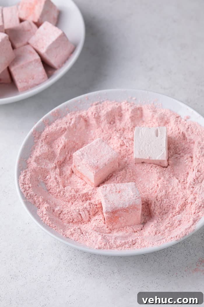 Homemade Strawberry Marshmallows: Soft, Fluffy Recipe 10 Cut strawberry marshmallows being dredged in strawberry powder and cornstarch.