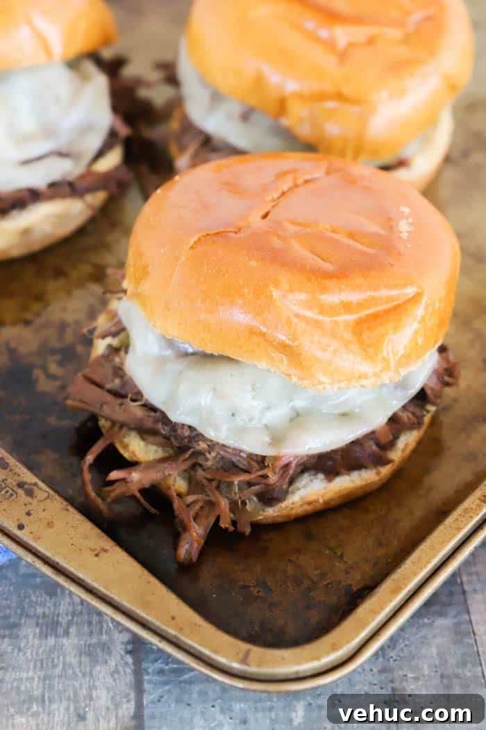 Slow-Cooker Shredded Beef Sandwich Recipe for Tender Pulled Beef 2 Slow Cooker Shredded Beef Sandwiches on a baking sheet