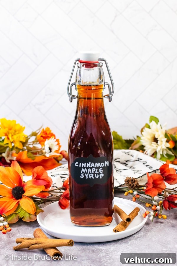 Bottle of cinnamon maple syrup A clear bottle filled with cinnamon maple syrup on a white plate.