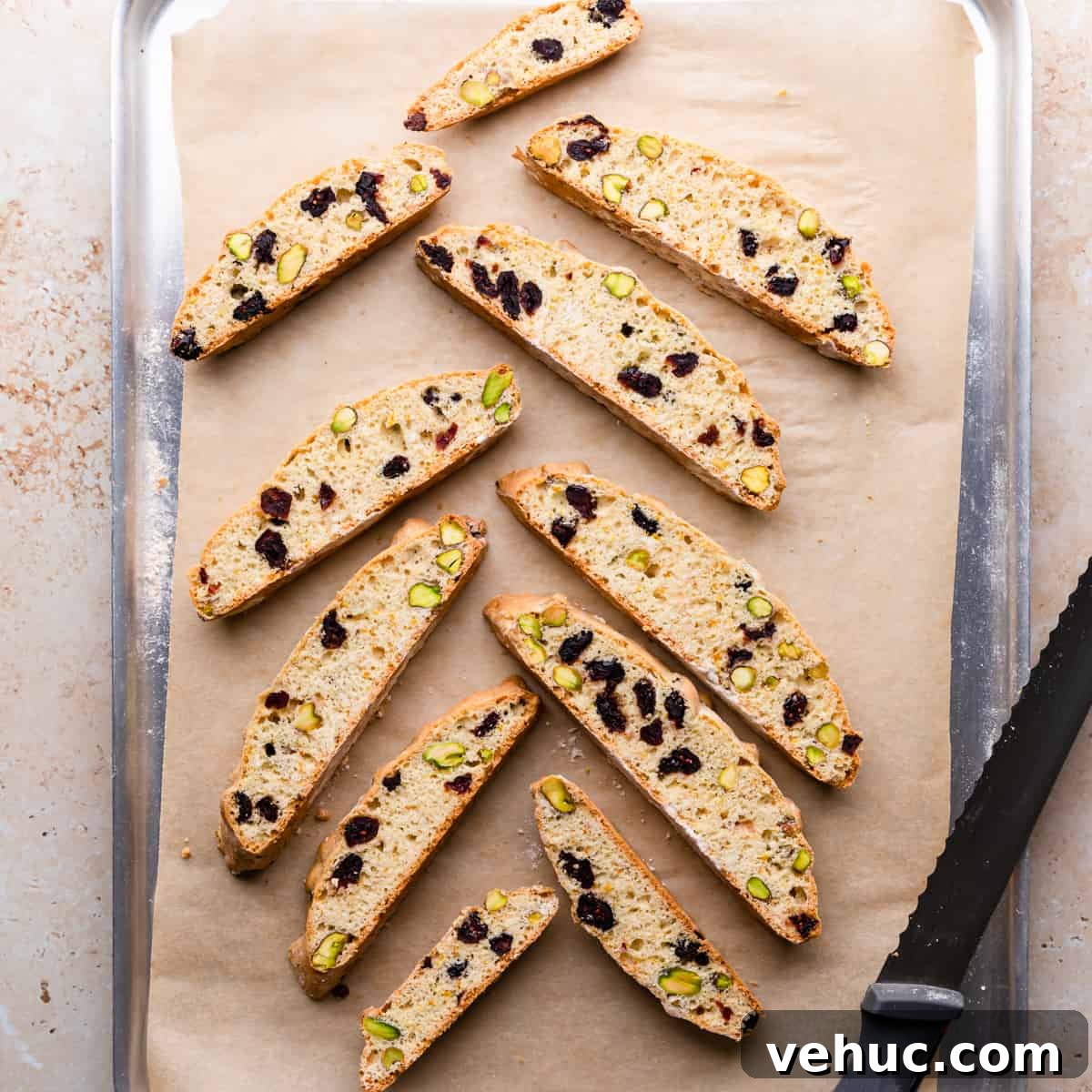 Cranberry Almond Biscotti Recipe for Crunchy Coffee Cookies 8 cranberry biscotti baked once on top of baking tray with serrated knife on side.