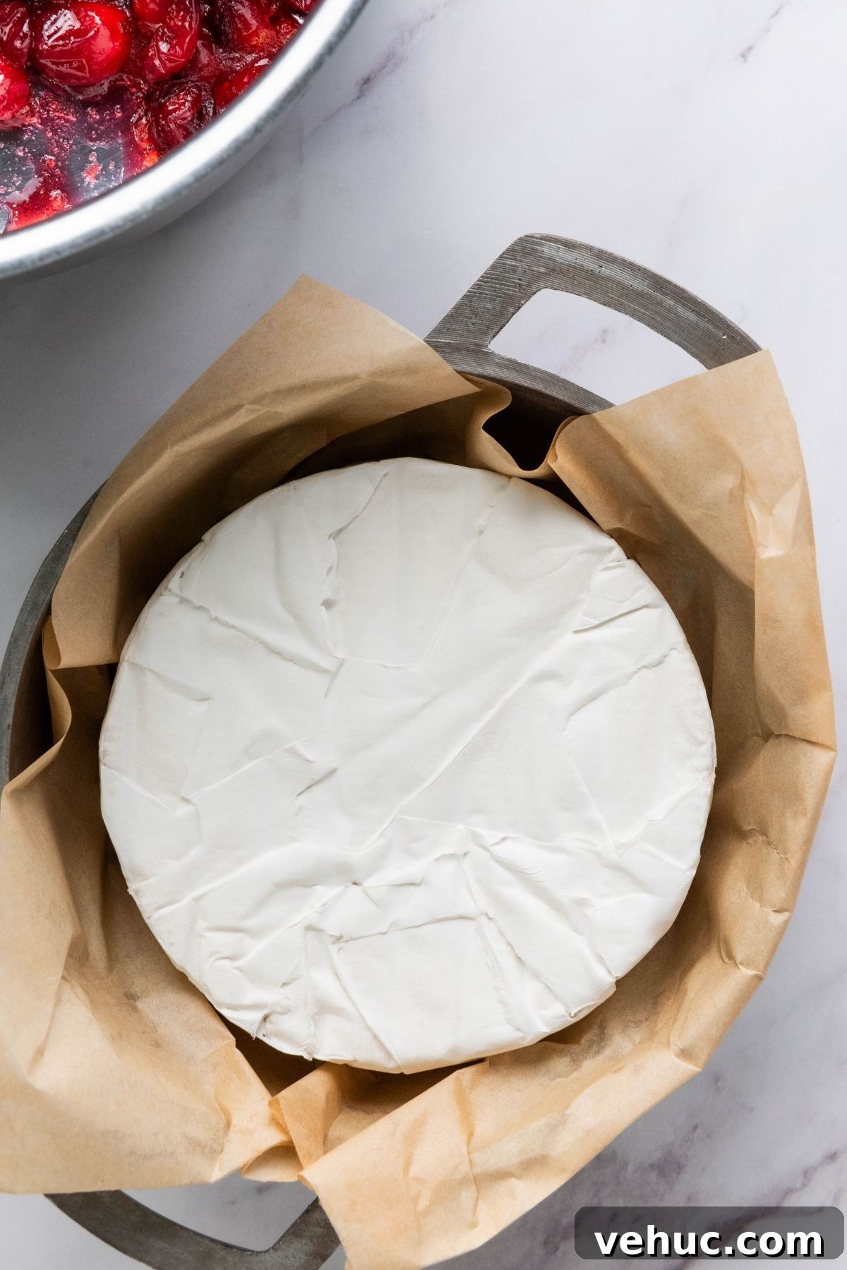 Baked Brie with Honey and Crispy Puff Pastry 4 Brie cheese tucked into a baking pan.