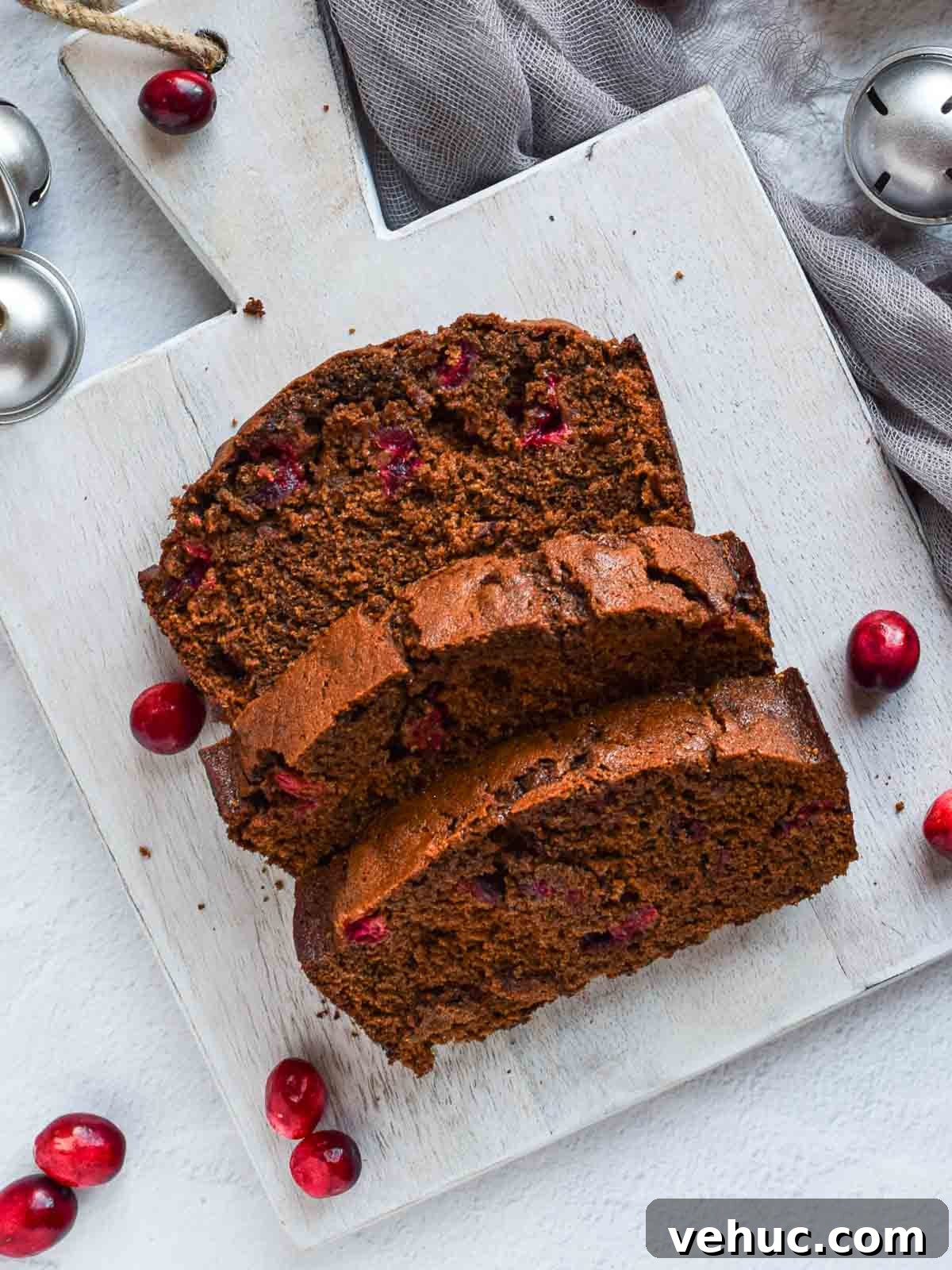 Cranberry Gingerbread Loaf Recipe with Zesty Ginger Glaze 2 Overhead of 3 slices of cranberry gingerbread loaf on grey board.