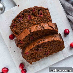Cranberry Gingerbread Loaf Recipe with Zesty Ginger Glaze 14 Overhead view of slices of cranberry gingerbread loaf on a grey board.