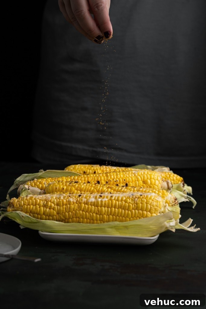 Grilled Corn on the Cob with Zesty Old Bay Seasoning 5 Adding old bay seasoning to grilled corn.