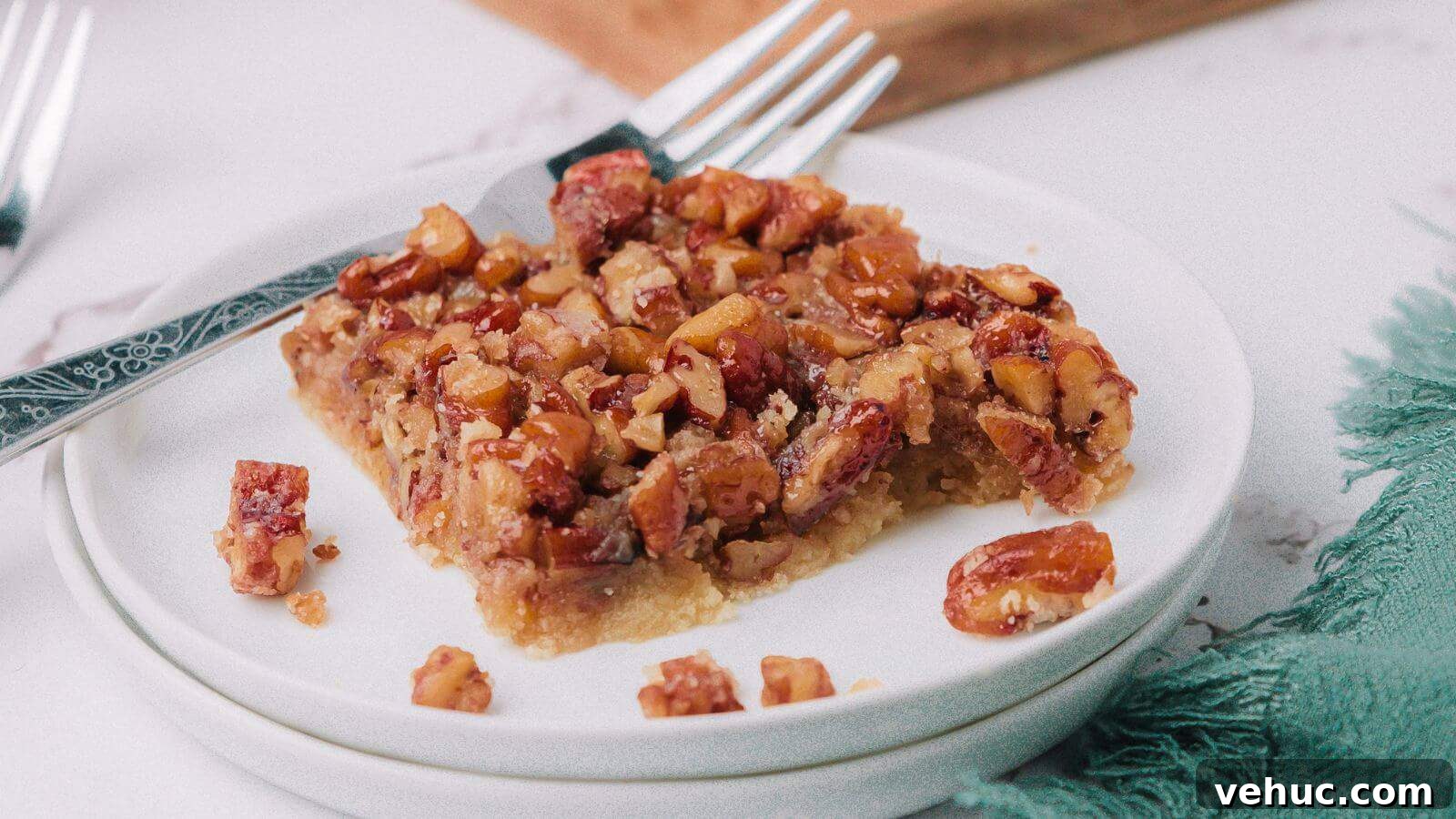 A piece of pecan pie on a white plate with a fork.