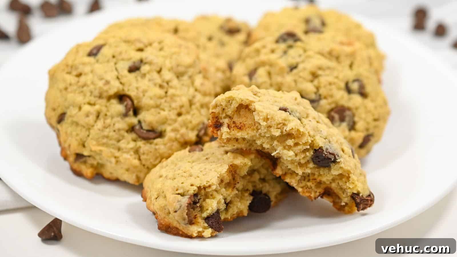 A plate of cookies on a white surface with front one broken in half.