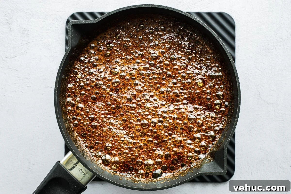 Kecap Manis Substitute: How to Make Sweet Soy Sauce at Home 4 Homemade sweet soy sauce (kecap manis) boiling and bubbling vigorously in a small saucepan.