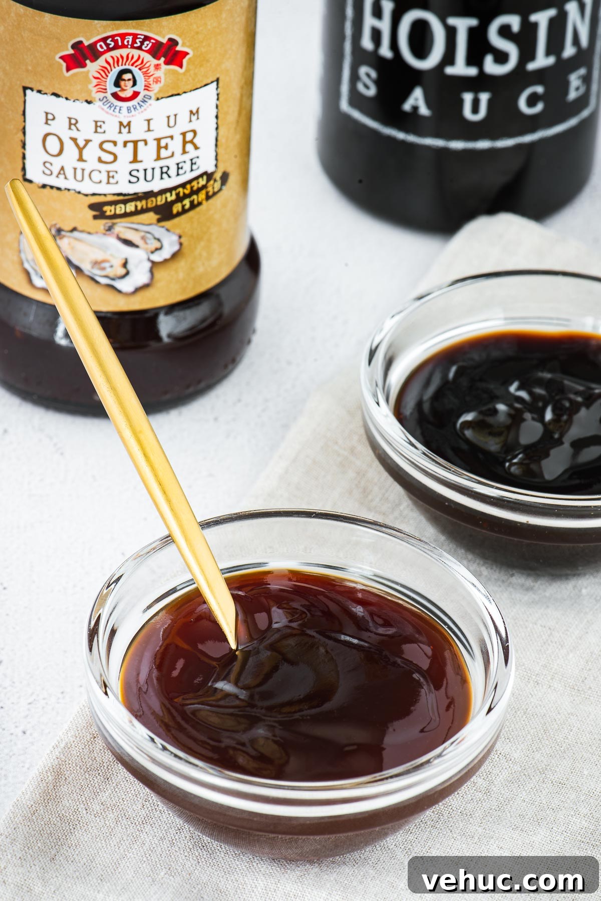 Kecap Manis Substitute: How to Make Sweet Soy Sauce at Home 6 Hoisin sauce vs oyster sauce in small glass bowls with bottles in the background.