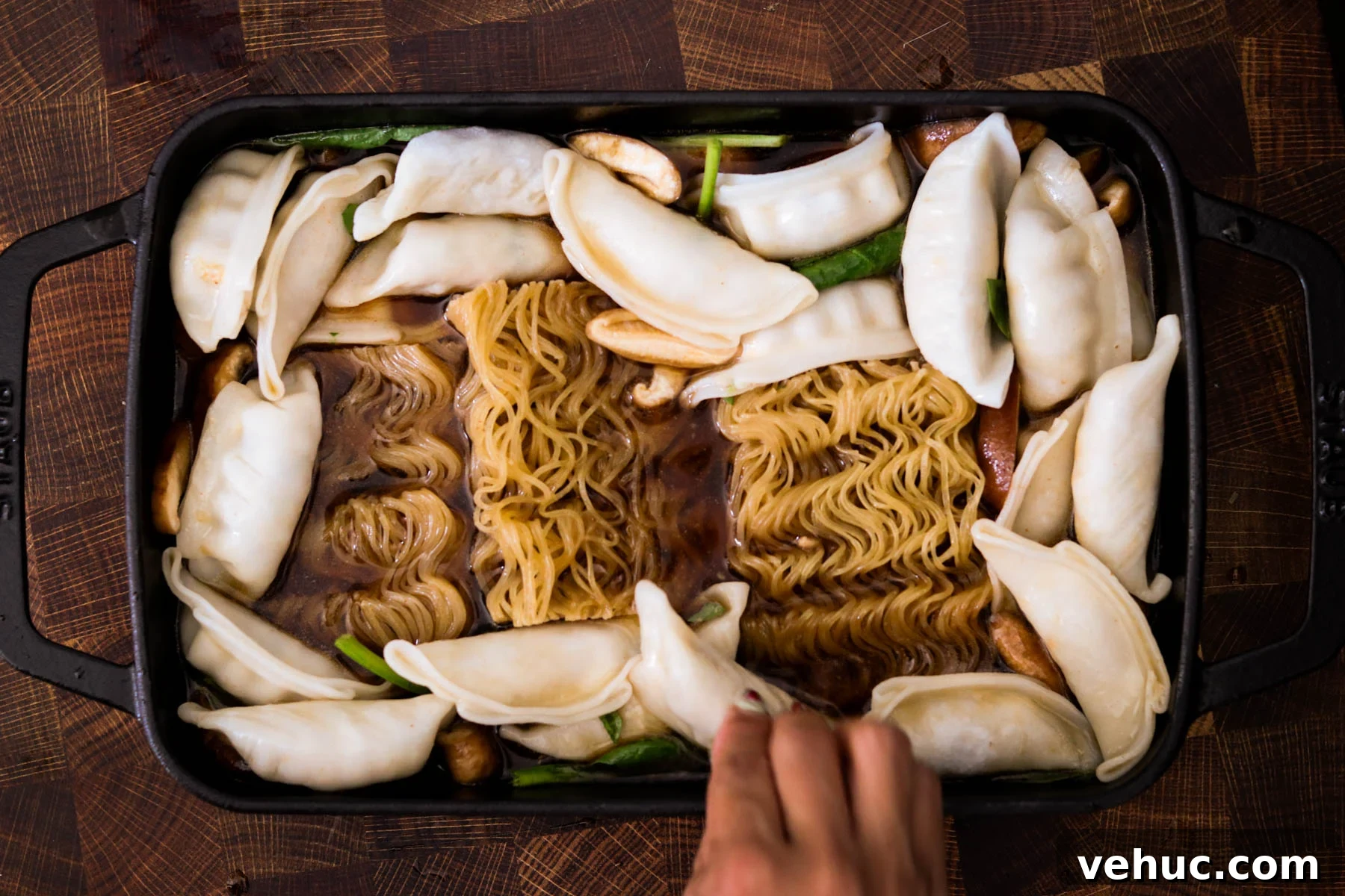 Crispy Baked Dumplings with Ramen: One-Pan Weeknight Dinner 6 Ramen cakes and frozen dumplings arranged in a baking dish with broth.