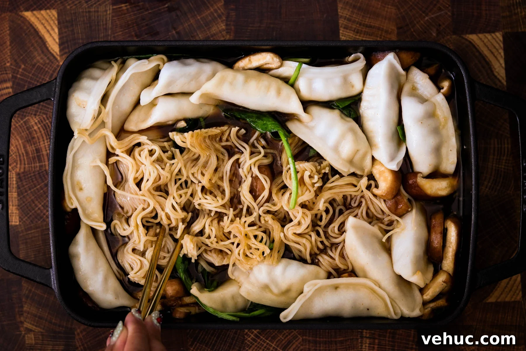 Crispy Baked Dumplings with Ramen: One-Pan Weeknight Dinner 8 Ramen cakes flipped and broken apart in the broth after removing foil, ready for final baking.