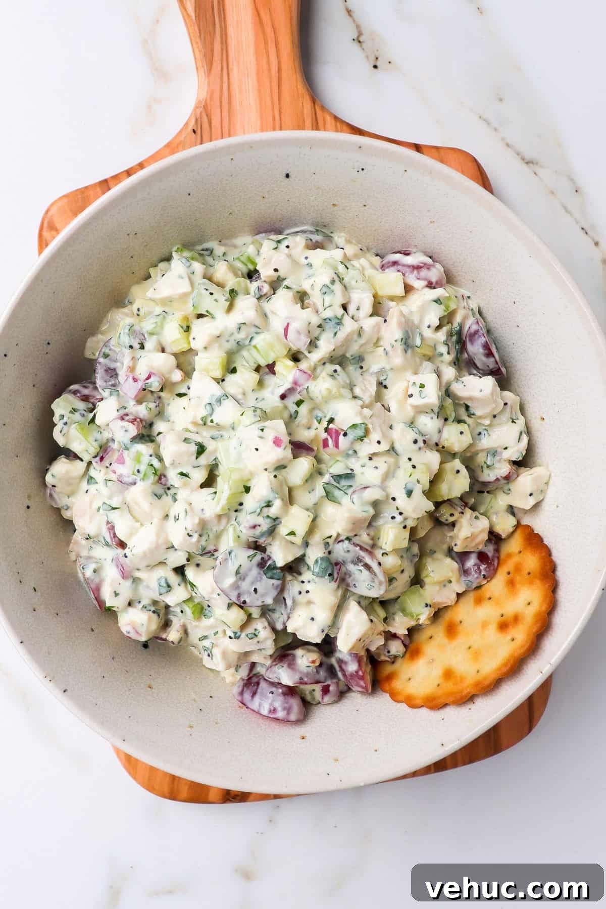 Salad in a bowl with a cracker.