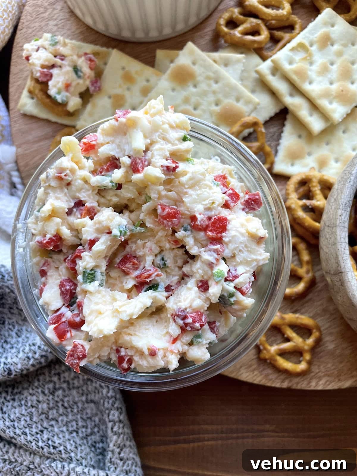Spicy Jalapeño Pimento Cheese Dip Recipe for Parties 2 A bowl of spicy pimento cheese surrounded by saltines and pretzels.
