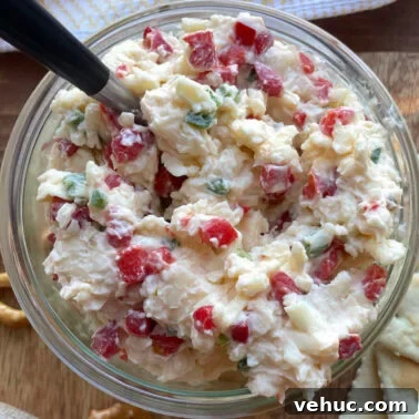 Spicy Jalapeño Pimento Cheese Dip Recipe for Parties 10 A bowl of creamy jalapeño pimento cheese made with white cheddar cheese with a spoon.