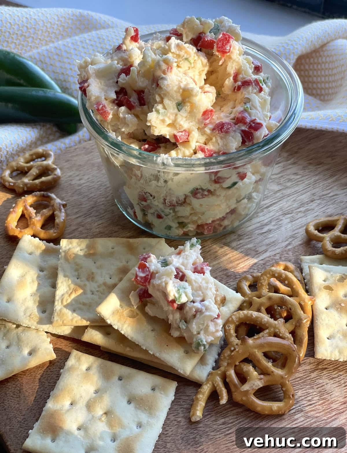 Spicy Jalapeño Pimento Cheese Dip Recipe for Parties 11 A jar of pimento cheese with jalapeños surrounded by saltines and pretzels.