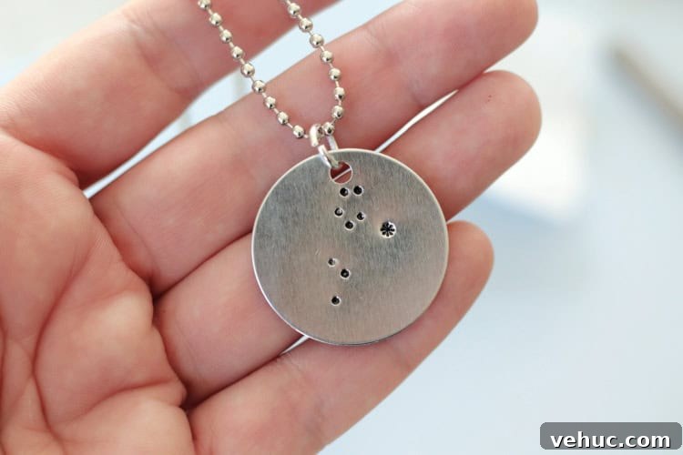 How to Make Stamped Constellation Necklaces (Video) 3 hand holding finished constellation necklace