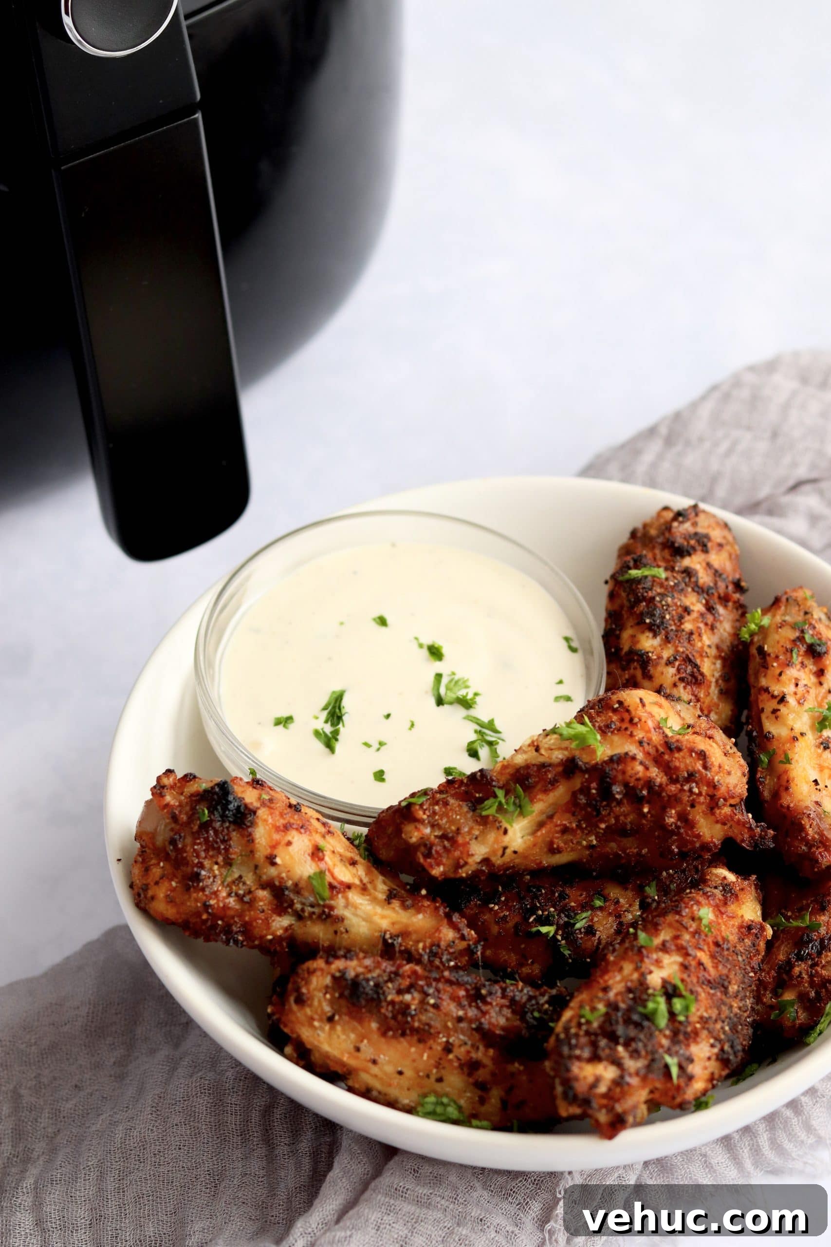 Crispy Air Fryer Chicken Wings Recipe for Perfectly Golden Wings 8 Crispy chicken wings in a bowl with an air fryer in the background