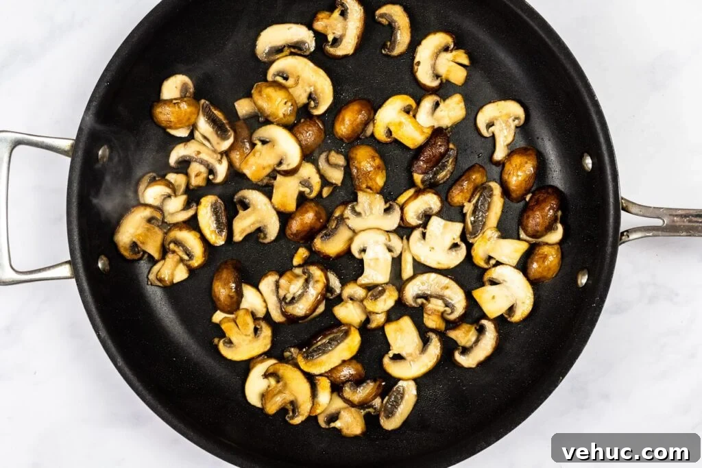 Creamy Garlic Mushroom Pasta Recipe — Quick Weeknight Comfort 4 Mushrooms cooking in a skillet.