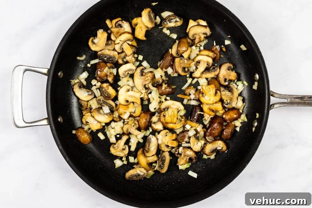 Creamy Garlic Mushroom Pasta Recipe — Quick Weeknight Comfort 5 Mushrooms, shallots and garlic cooking in a skillet.