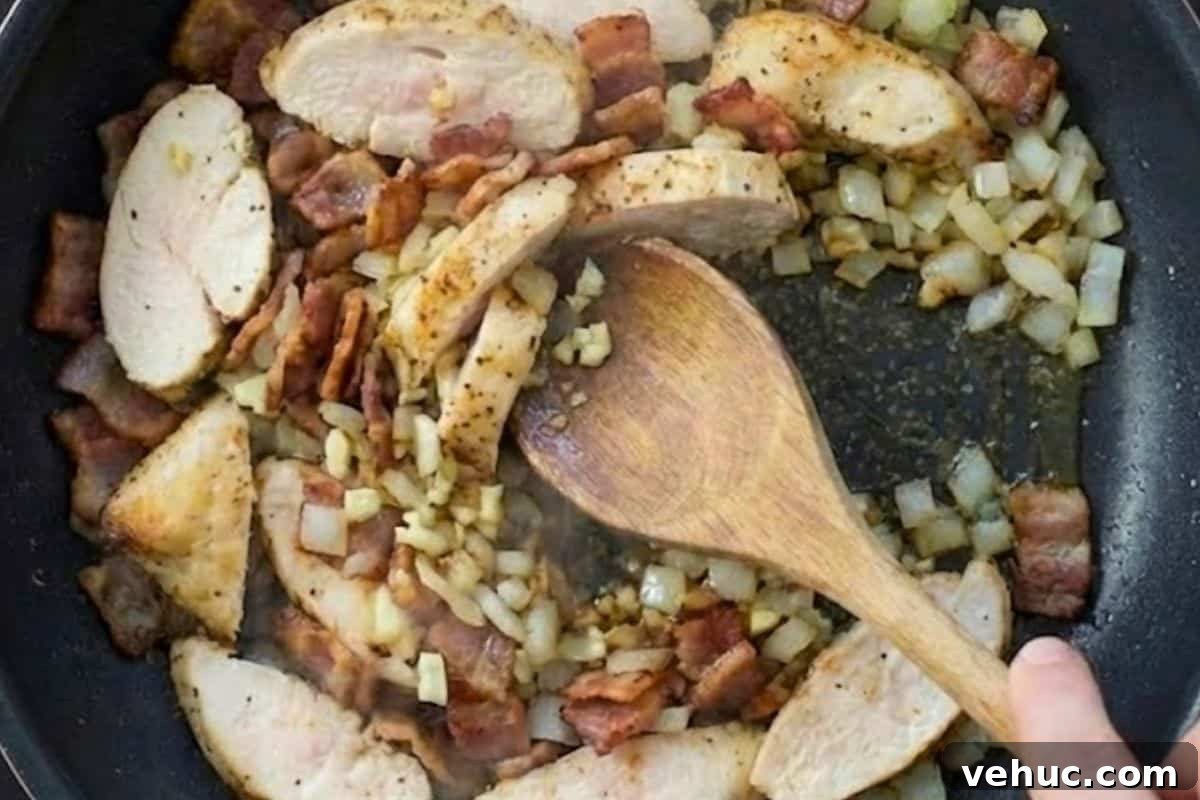 Lighter Chicken Carbonara Recipe for Weeknight Meals 6 Heat a non stick frying pan over medium high heat and cook the onion and bacon until the bacon is crisp, about 6 minutes, then add the garlic and chicken and cook until the chicken is cooked through.
