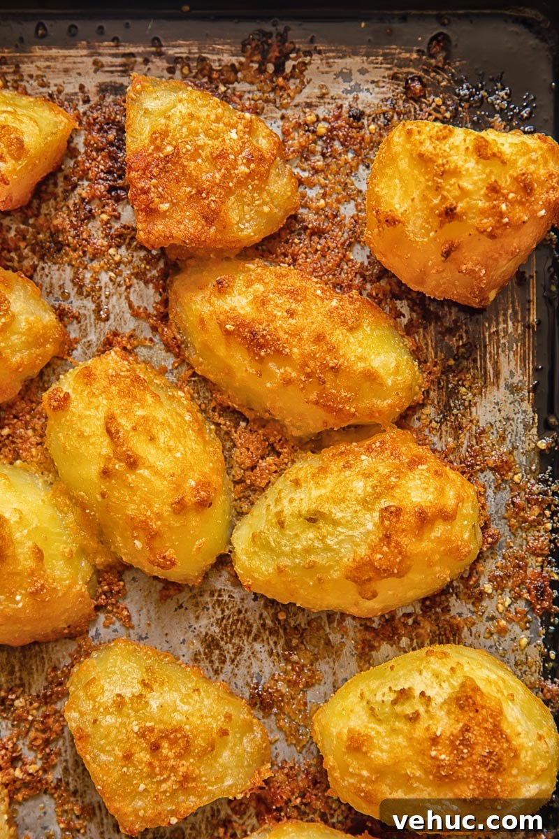 Top down shot of parmesan crusted potatoes on a baking tray