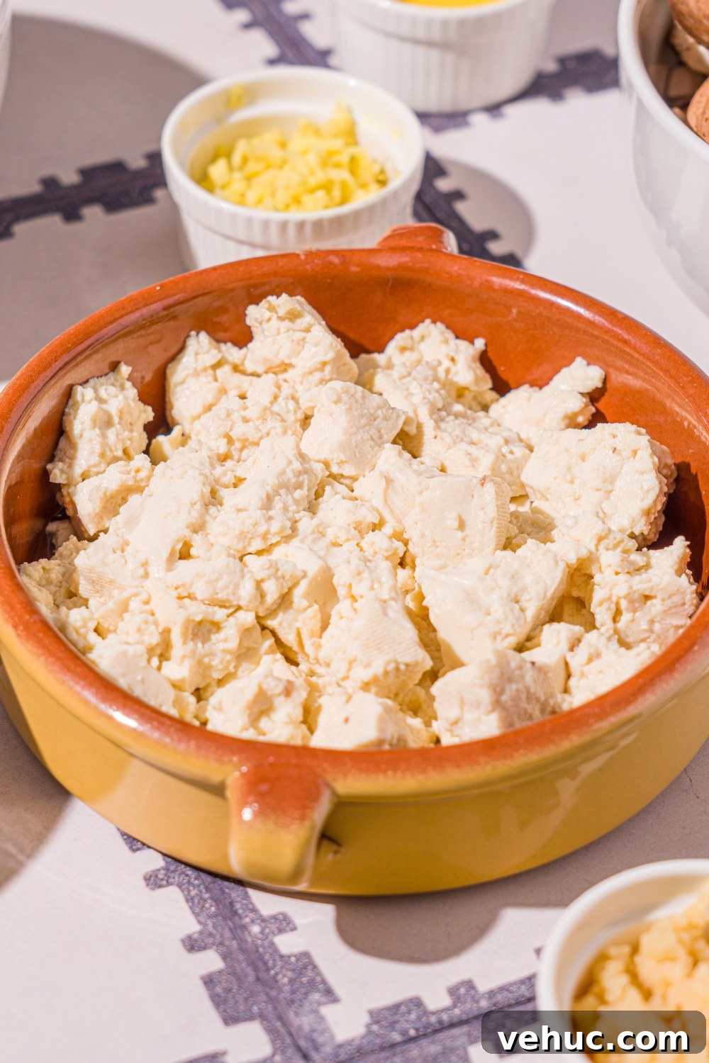 Crispy Rice Paper Veggie Dumplings: Viral TikTok Recipe 5 A small bowl with crumbled tofu. The bowl is on a tiled counter with small bowls of ingredients.