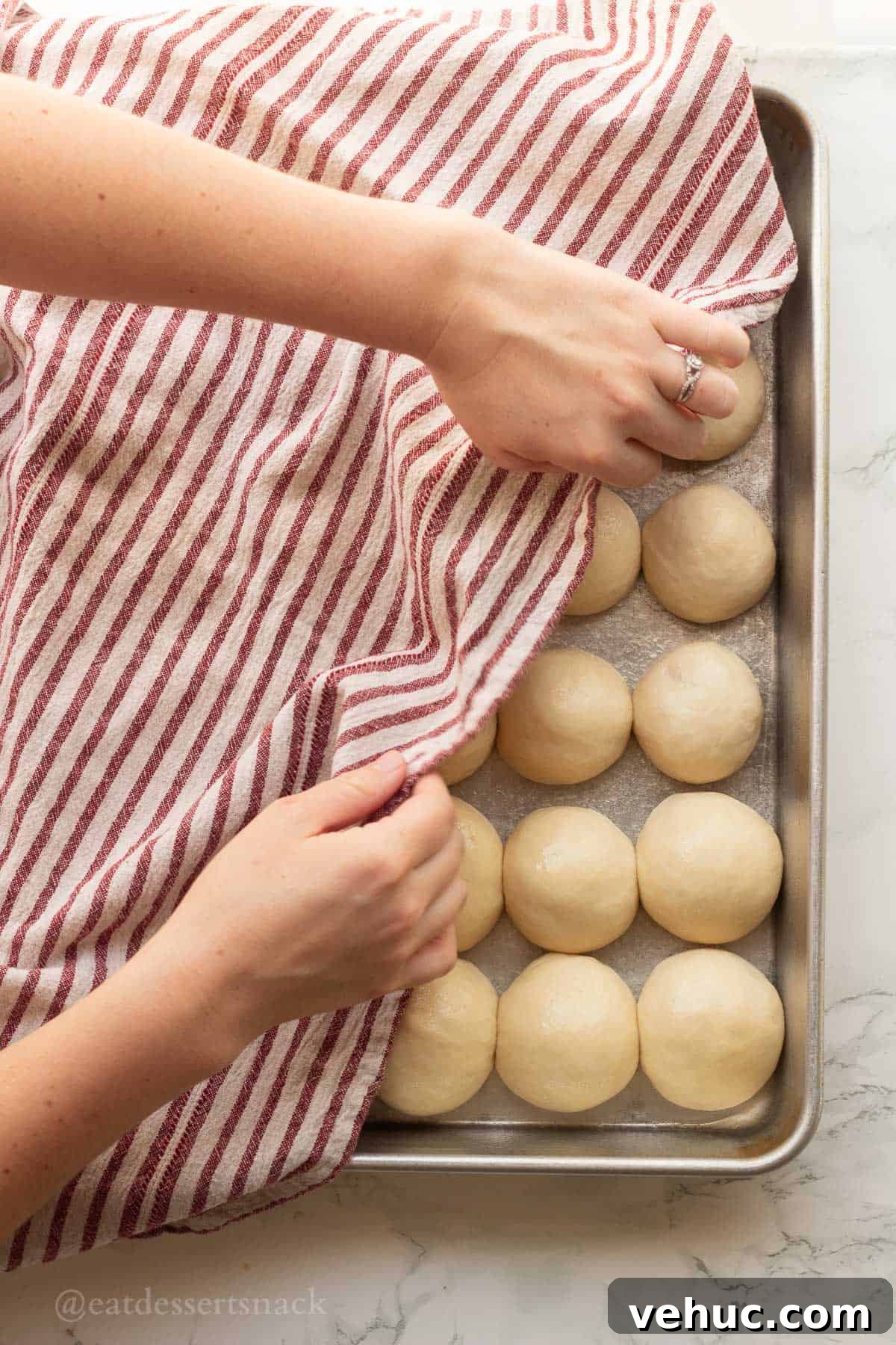 Classic Old-Fashioned Yeast Rolls Recipe 9 Dish towel covering raw dinner roll dough in metal pan.