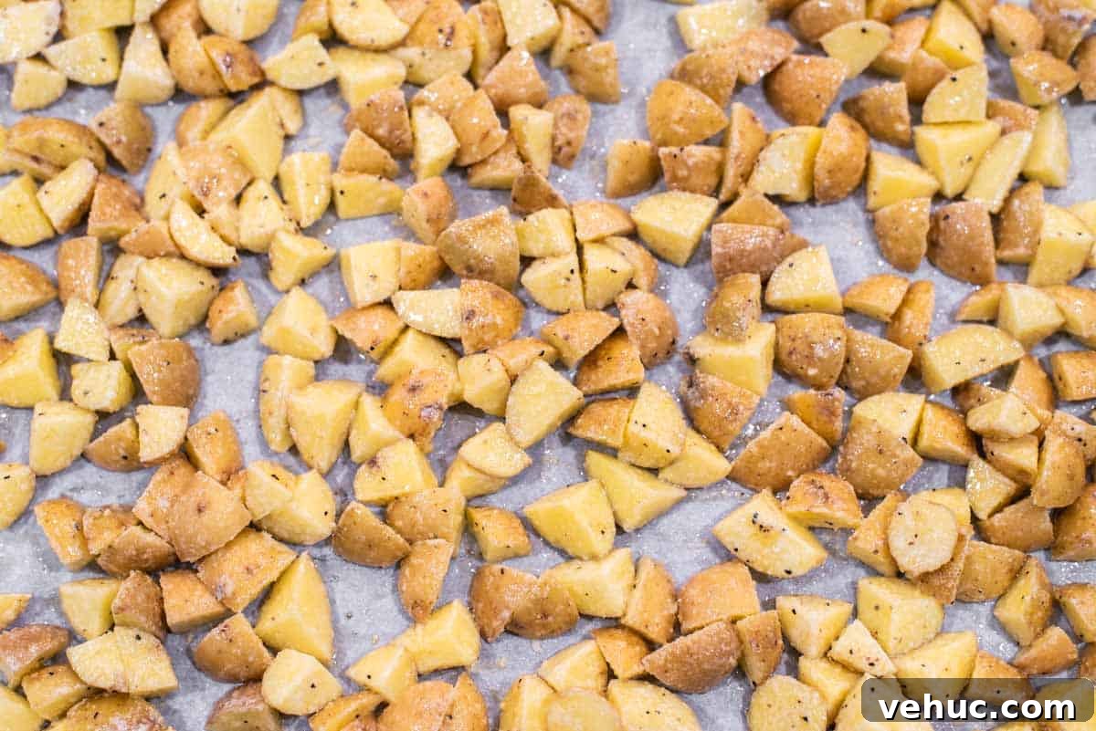 Diced potatoes on parchment-lined baking sheet.
