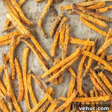 overhead shot of sweet potato fries on parchment-lined baking sheet