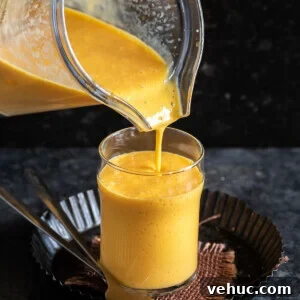 Creamy Mango Milkshake Recipe — Refreshing Tropical Drink 5 mango milkshake being poured into a glass from a blender