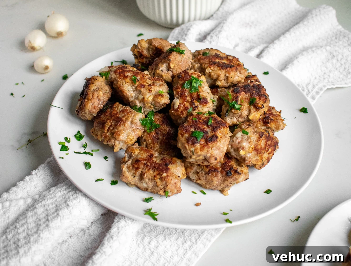Danish meatballs on a plate with potatoes on the side.
