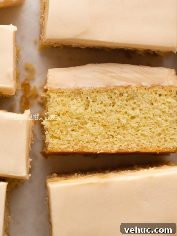 Classic Four-Egg Yellow Sheet Cake with Chocolate Frosting 9 Rectangular slices of butterscotch krimpets placed on a parchment paper lined background with center slice on its side.