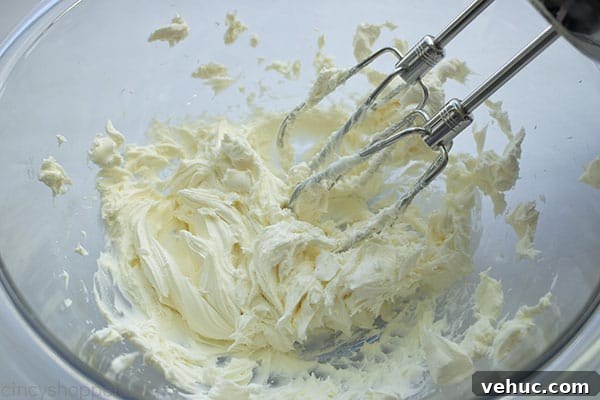 Beating cream cheese in a mixing bowl