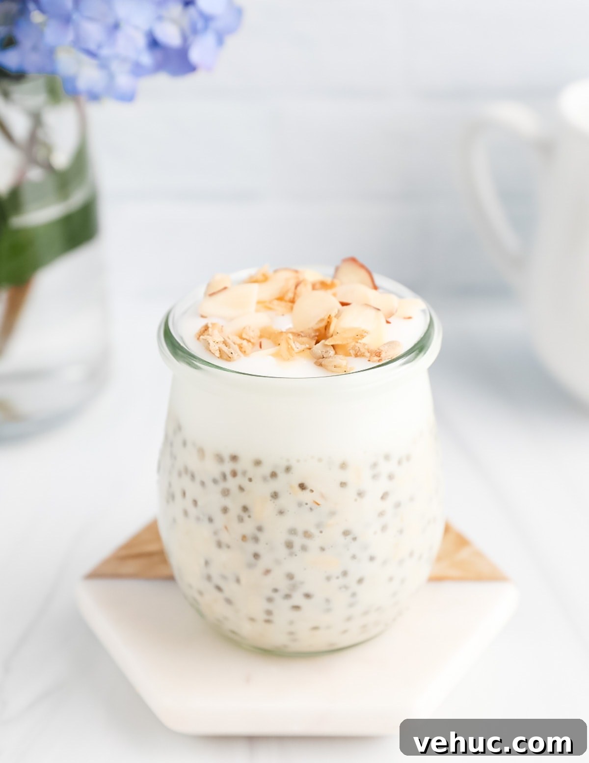 Creamy Vanilla Overnight Oats Recipe for Busy Mornings 2 Overnight oats and yogurt in a clear cup. They are garnished with nuts and granola.