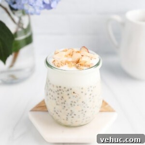 Creamy Vanilla Overnight Oats Recipe for Busy Mornings 12 A clear jar filled with vanilla overnight oats with chia seeds that is topped with granola and nuts.