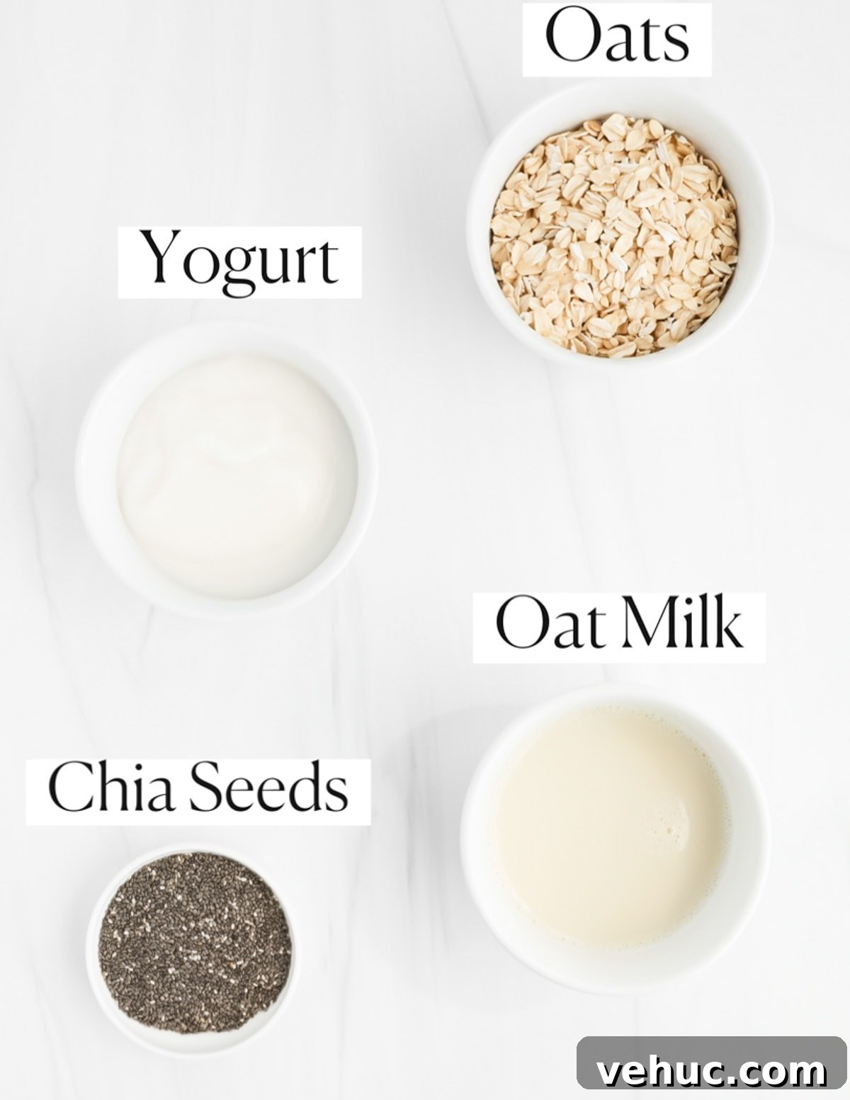 Creamy Vanilla Overnight Oats Recipe for Busy Mornings 3 Labeled ingredients in small white bowls including: oats, yogurt, oat milk, and chia seeds.