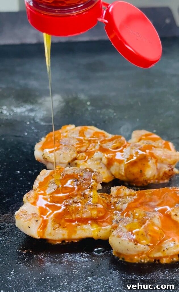 Honey-Lemon Buffalo Chicken Sandwich Recipe for Tangy Flavor 3 adding hot honey to chicken