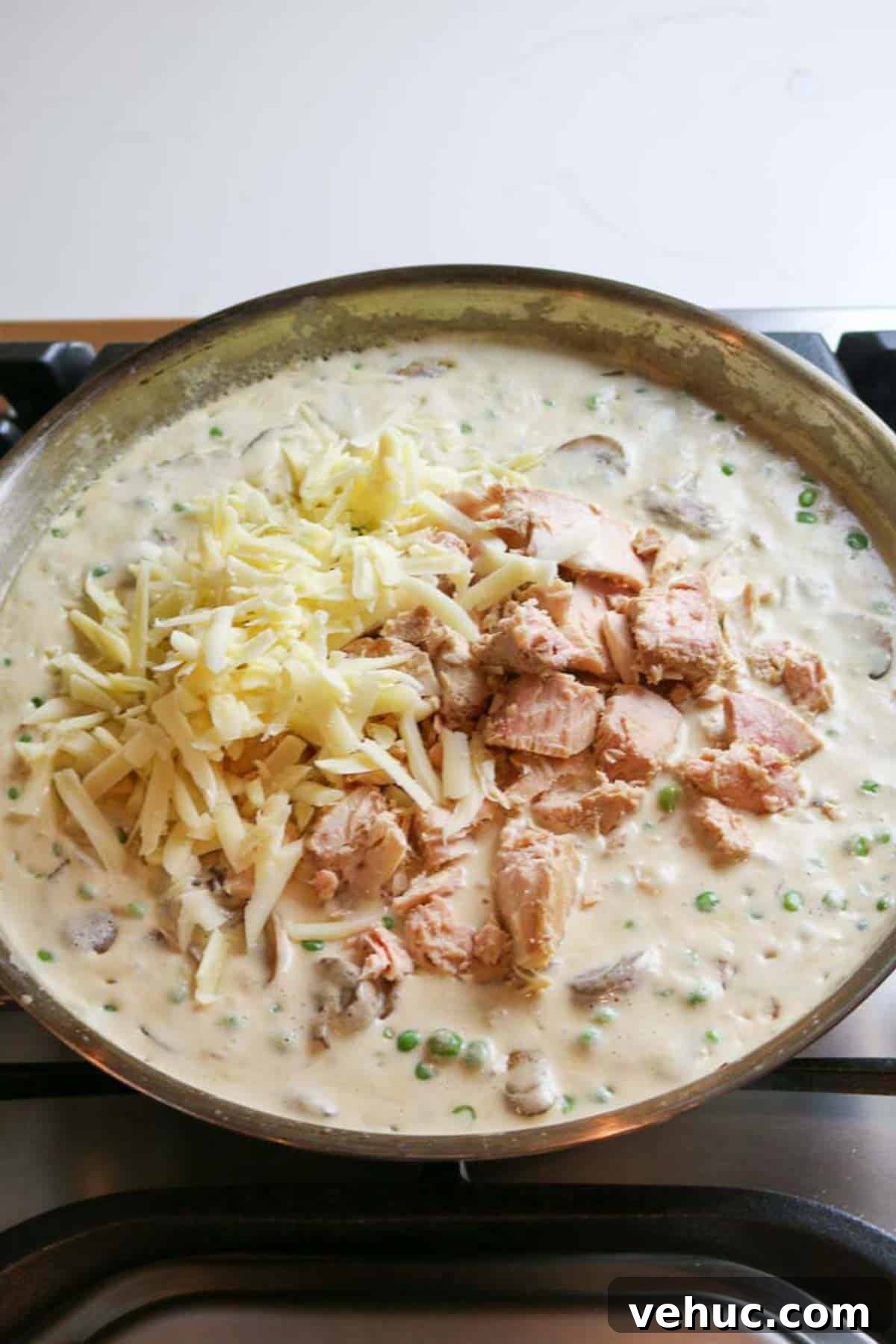 Tuna Noodle Casserole from Scratch (No Canned Soup) 8 flaky tuna with cheese added to creamy mixture in skillet.