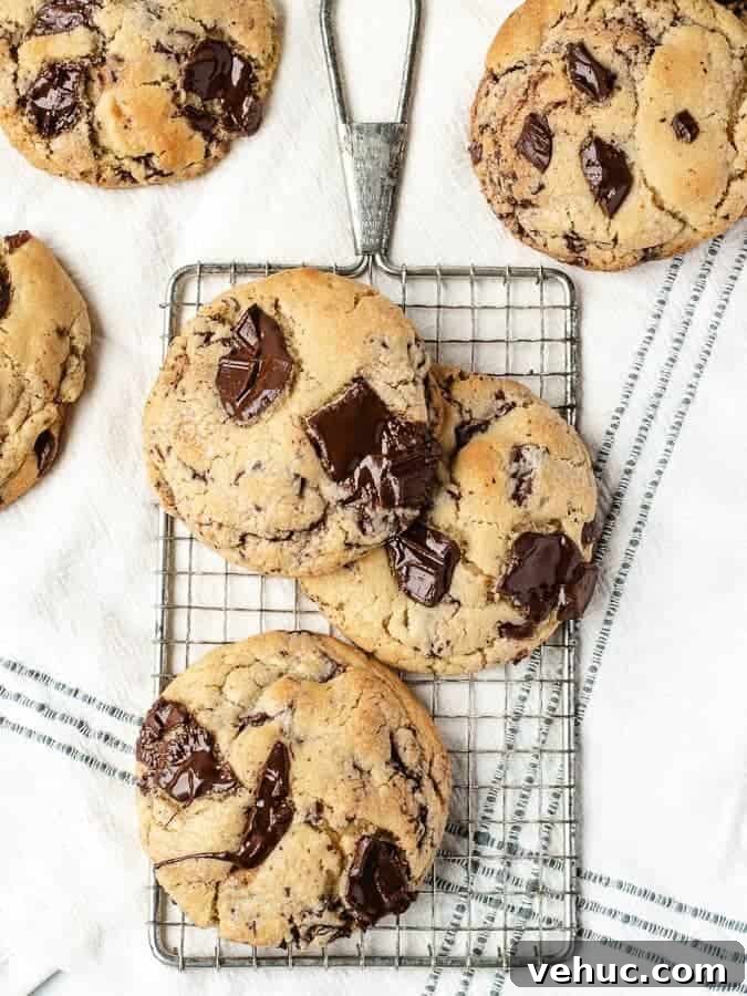 Ultimate Chocolate Chip Cookie Recipe for Gooey, Crispy Results 4 Overhead shot of big soft chocolate chip cookies on a cooling rack with more cookies surrounding